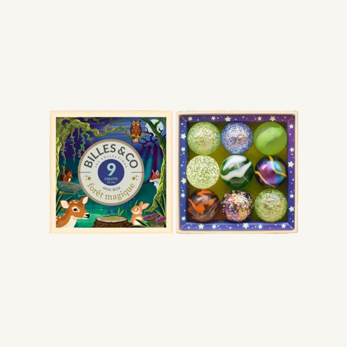 A boxed set of nine decorative glass Forest Magic shooter marbles displayed beside its illustrated lid. The lid features woodland artwork with the brand name Billes & Co and the text '9 carats pour la forêt magique.
