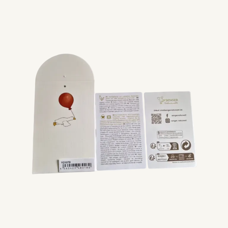 Three flat printed cards or inserts shown on a plain white background: a tall off-white card with a red balloon illustration and barcode on the left, and two shorter white informational cards with text and logos in the center and right.