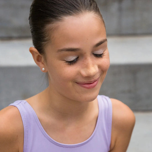 A young girl with her hair in a neat bun wearing a Namaki Winter eyeshadow trio