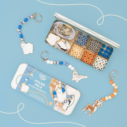 A Cotton Twist children's bead keyring beading kit with polar bear and polar fox charms, shown with its storage box and packaging on a light blue background.