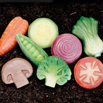 Colorful play stone vegetables from Yellow Door, lying on the soil 