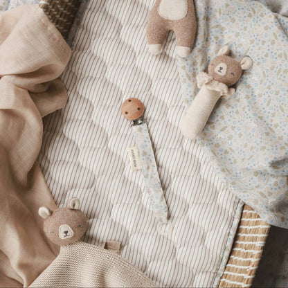 Three teddy bear toys on a textured fabric surface