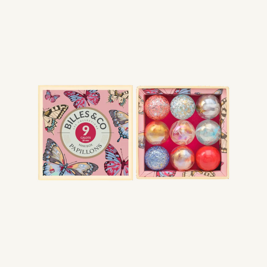 Billes & Co. 9 pink butterfly shooter marbles in an open gift box, showing the pink butterfly-patterned lid on the left and the 9 round marbles on the right.