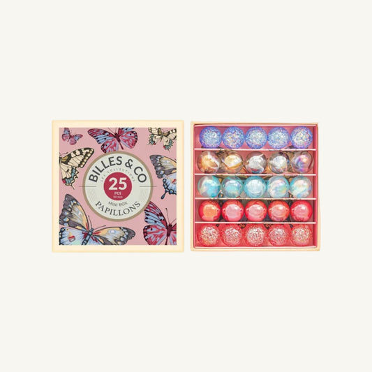 A boxed set of 25 Butterly marbles by Billes & Co, shown with the pink butterfly-patterned lid on the left and the open wooden tray of round marbles on the right against a white background.