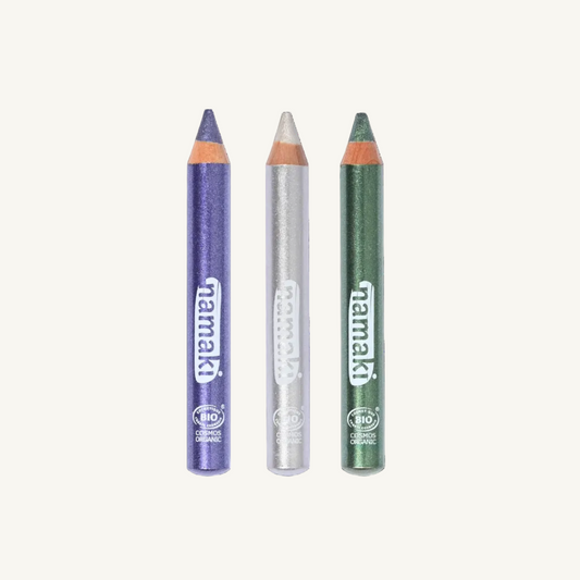Three Namaki Winter glittery make-up pencils lined up vertically on a white background, featuring a purple pencil, a silver pencil and a green pencil