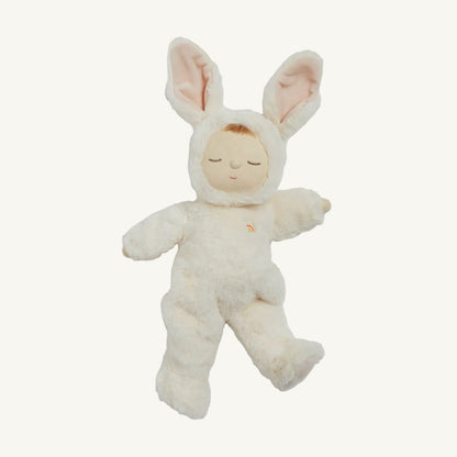 A plush bunny doll wearing a cream-colored bunny suit with pink inner ears and a small embroidered rainbow on the chest, isolated on a white background.