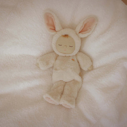 Plush toy in a bunny costume lying on a soft, light-colored surface
