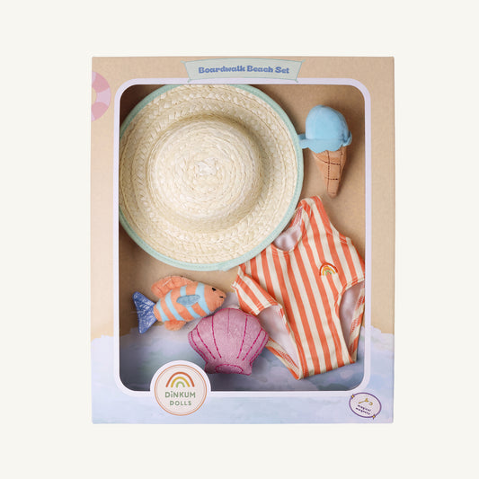 Dinkum Dolls Boardwalk Beach Set toy set in its original packaging, featuring a woven straw hat, orange and white striped swimsuit, pink seashell, and small toy fish on a cardboard display box.
