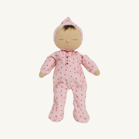 A Dozy Dinkum doll with a beige fabric face and hands, wearing a pink hooded one-piece outfit with small red Strawberry's, shown against a plain off-white background.