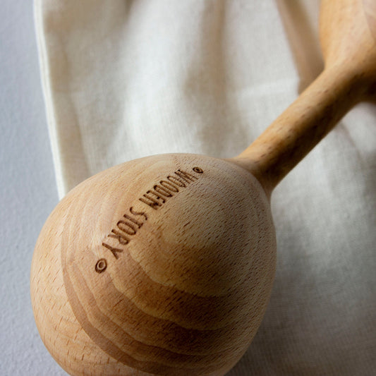 Wooden baby rattle with 'Wooden Story' branding on a light background