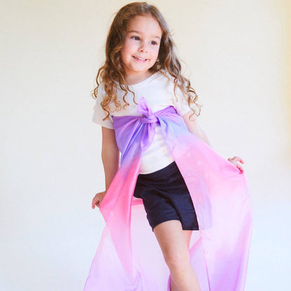 Child holding a long, colorful scarf against a white background