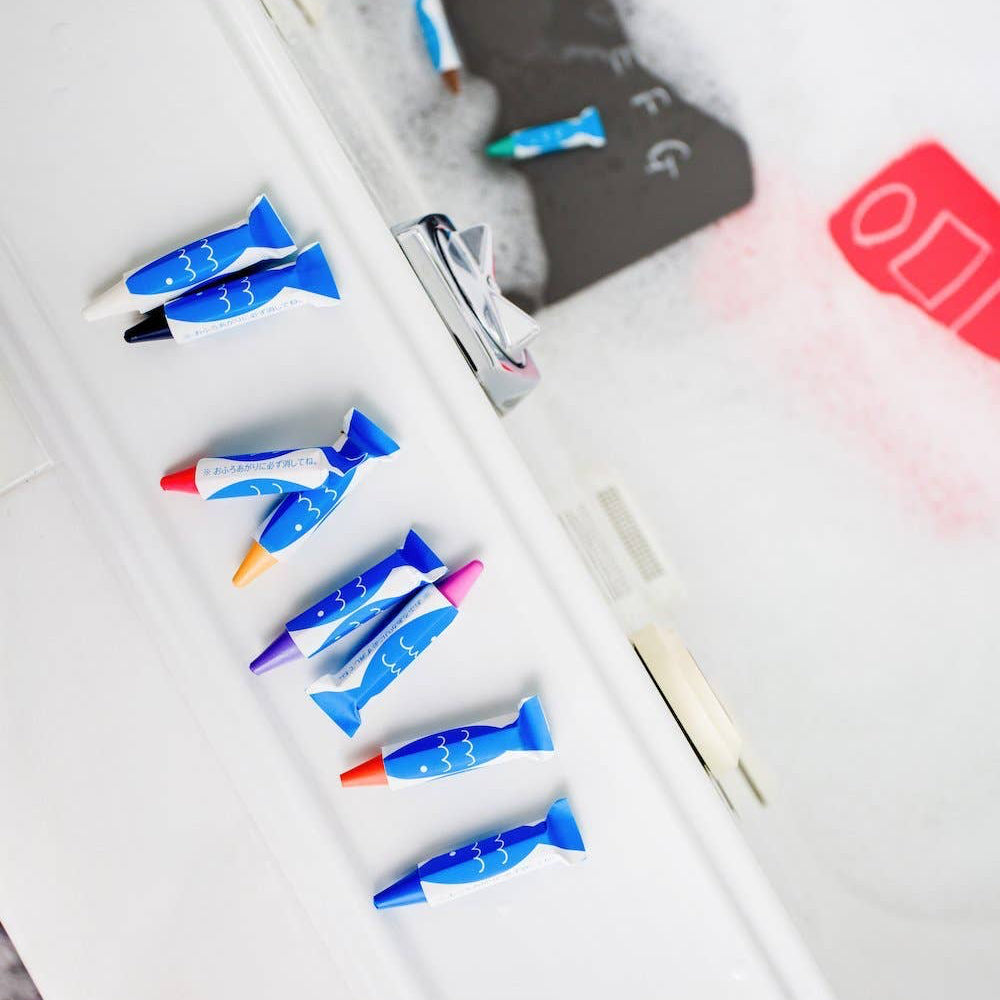 Colorful bath crayons on a white surface with a blurred background