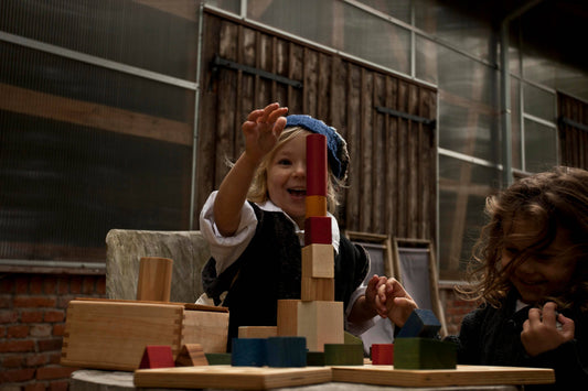 Child playing with wooden building blocks in an indoor setting