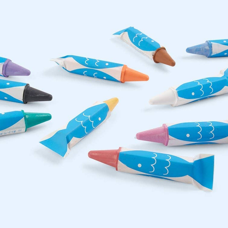 Colorful whale-shaped bath crayons on a white background