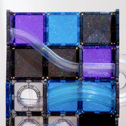 Multiple glittery CONNETIX tiles in purple, blue, black, and clear, connected by curved transparent tubes.